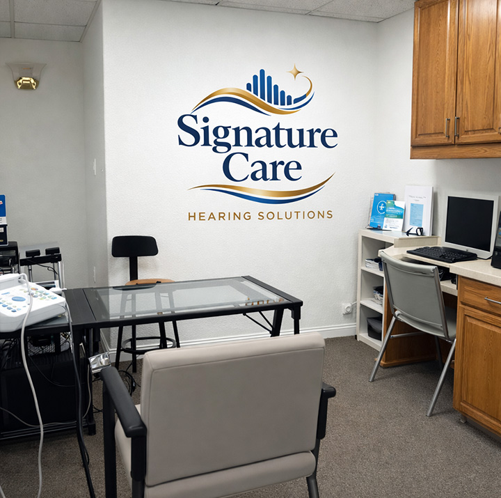 Signature Care Hearing Solutions fitting room with logo on the wall